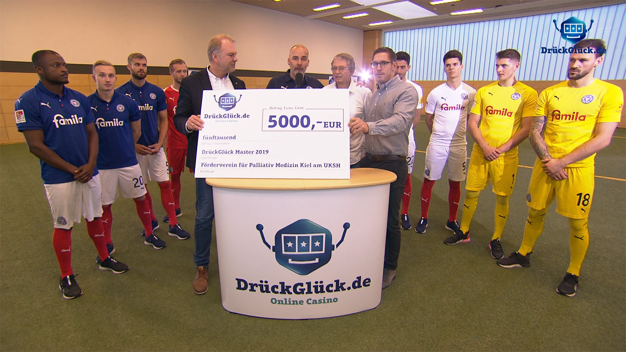 Spendenübergabe: DrückGlück.de überreicht einen Scheck über 5.000 Euro im Beisein von Fußballspielern Spendenübergabe: DrückGlück.de überreicht einen Scheck über 5.000 Euro im Beisein von Fußballspielern