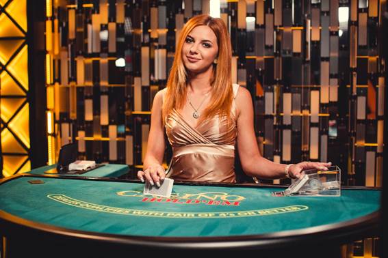 A live dealer from Evolution Gaming prepares to shuffle at a live Casino Hold’em table